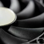 Macro close-up of a modern computer cooling fan blade, showcasing intricate details.