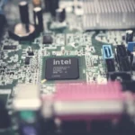 Detailed image of a computer motherboard highlighting an Intel chip with surrounding components.