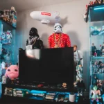 TV set surrounded with figurines and souvenir of comic character and movie heroes