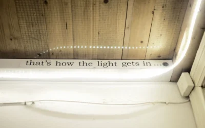 High angle of text written on window decorated with shiny lights reflecting in glass