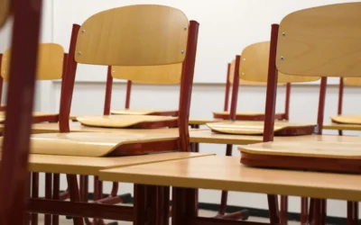 A modern and empty classroom featuring wooden chairs and desks with a focus on education and learning spaces.
